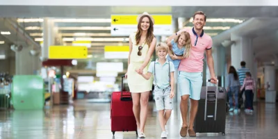 Çocuklu bir aile havalimanında valizleriyle seyahat ederken; konforlu ve güvenli havalimanı transfer hizmetleri.